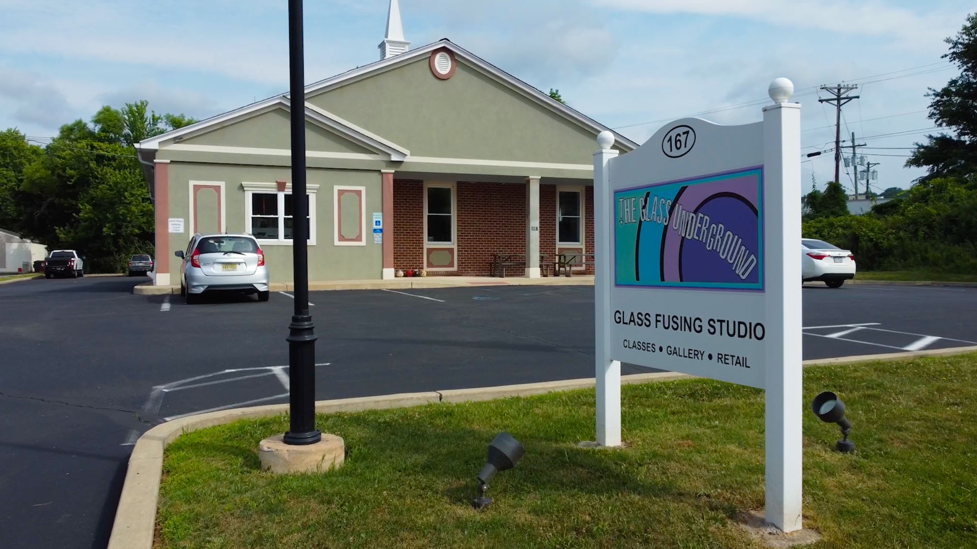 Tim Carey and Meryl Raiffe sharing a high-five inside the glass studio, a moment of momentum